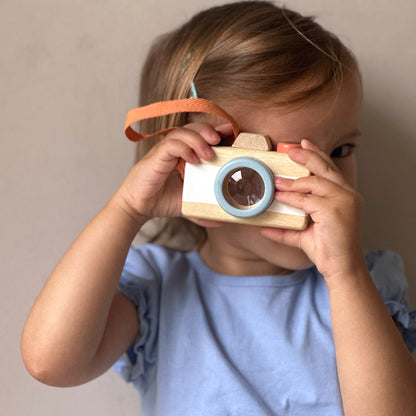 Child playing with wooden camera 