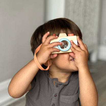 Child playing with wooden camera 